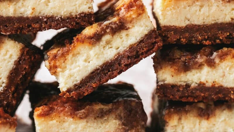 stacked cheesecake bars on parchment paper