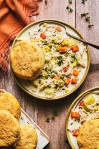 chicken soup with vegetables and biscuit in bowl on table
