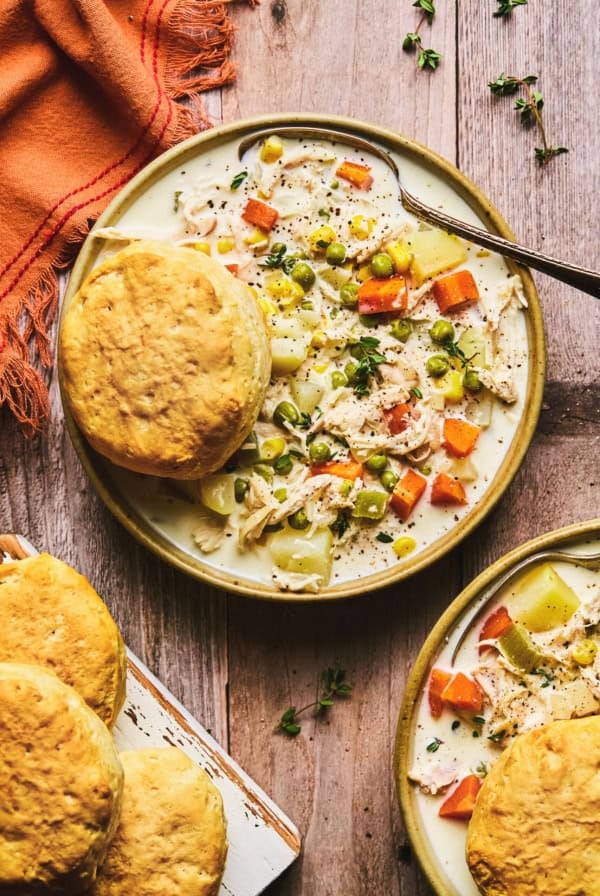 chicken soup with vegetables and biscuit in bowl on table