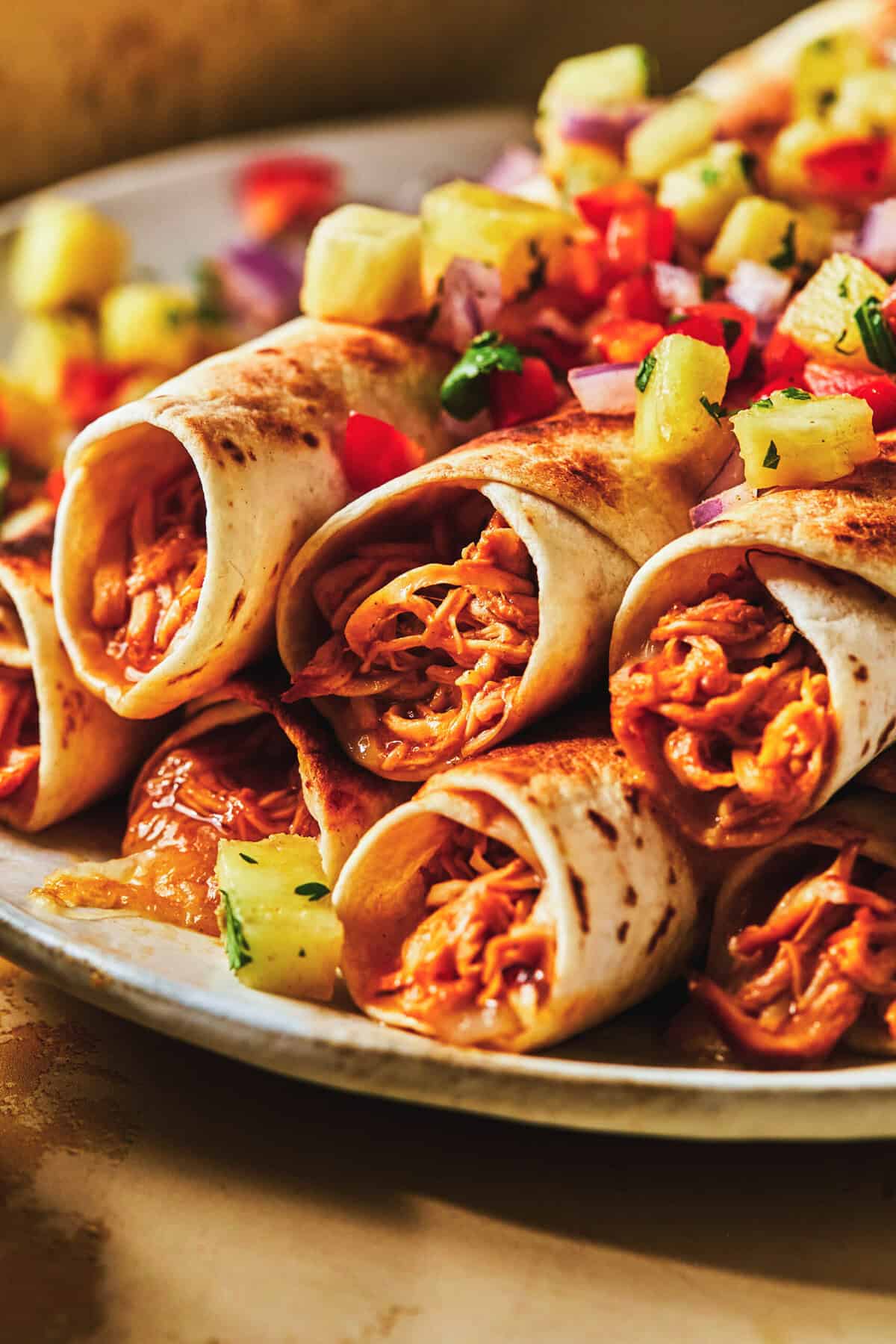 lėkštėje sukrauti susmulkinti vištienos taquitos