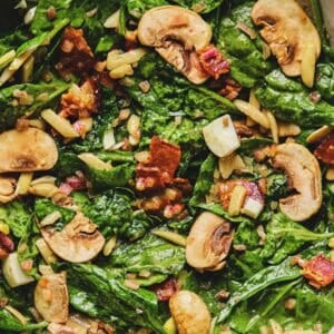 Overhead close up of spinach salad with hot bacon dressing.