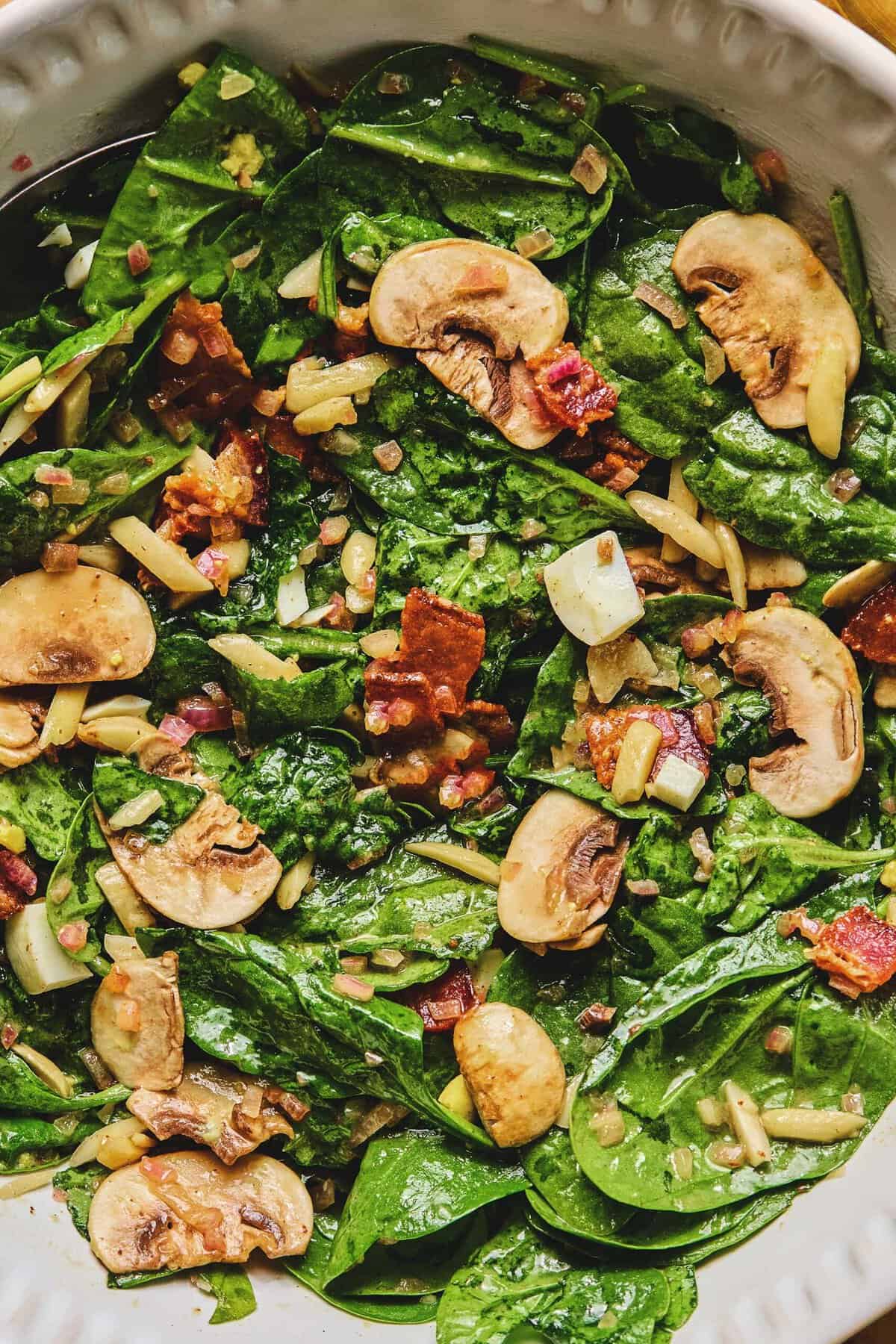 Overhead close up of spinach salad with hot bacon dressing.